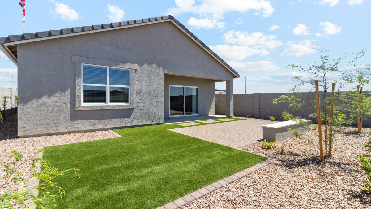 Outdoor covered patio with seating area overlooking a well-maintained lawn, perfect for relaxation.