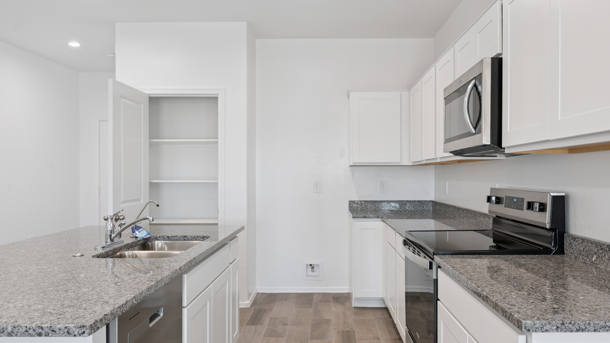Bright and spacious kitchen with granite countertops, stainless steel appliances, and an island with bar seating.