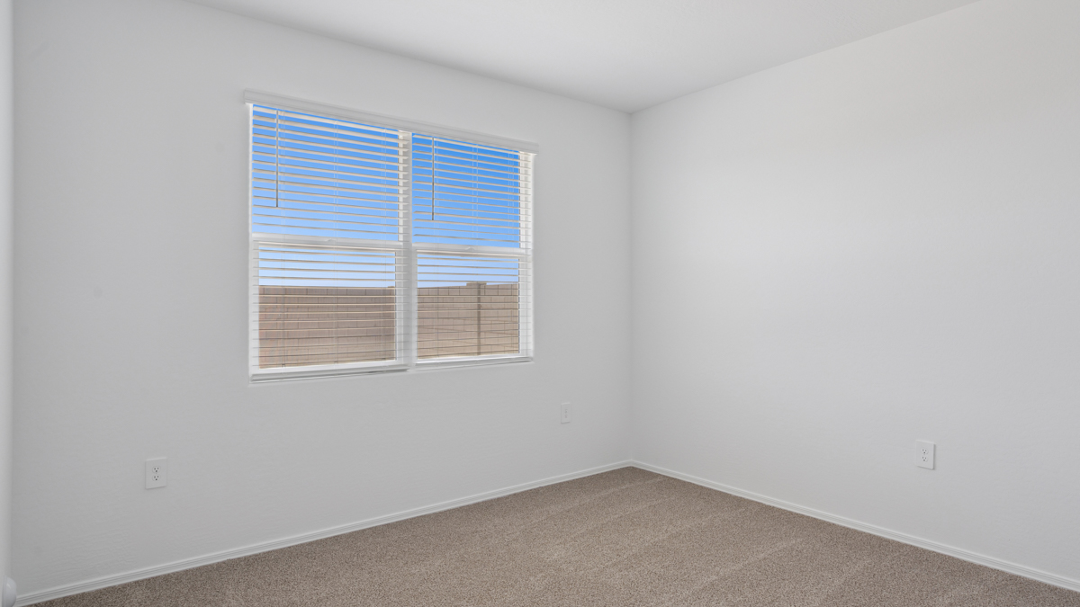 A spacious primary bedroom emphasizing open space and natural lighting.