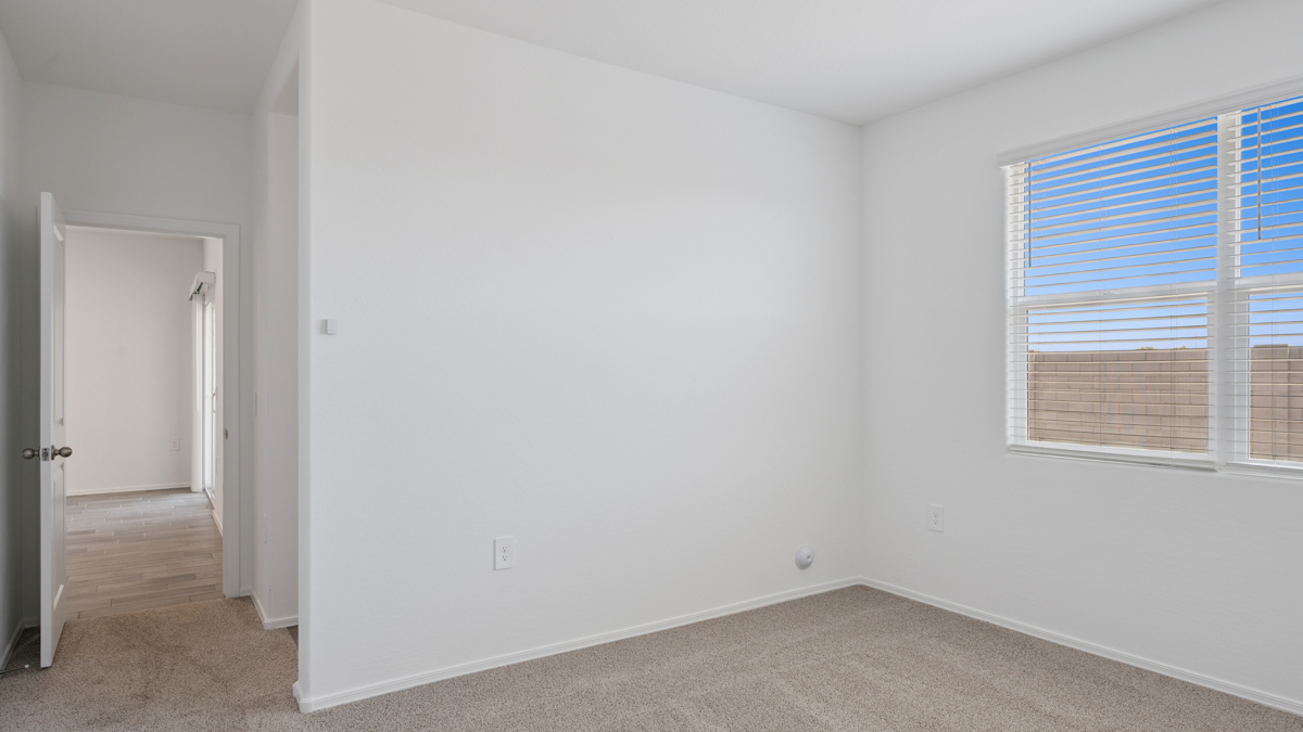 A spacious primary bedroom emphasizing open space and natural lighting.