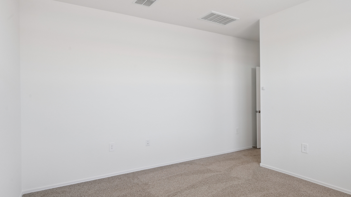 A spacious primary bedroom emphasizing open space and natural lighting.