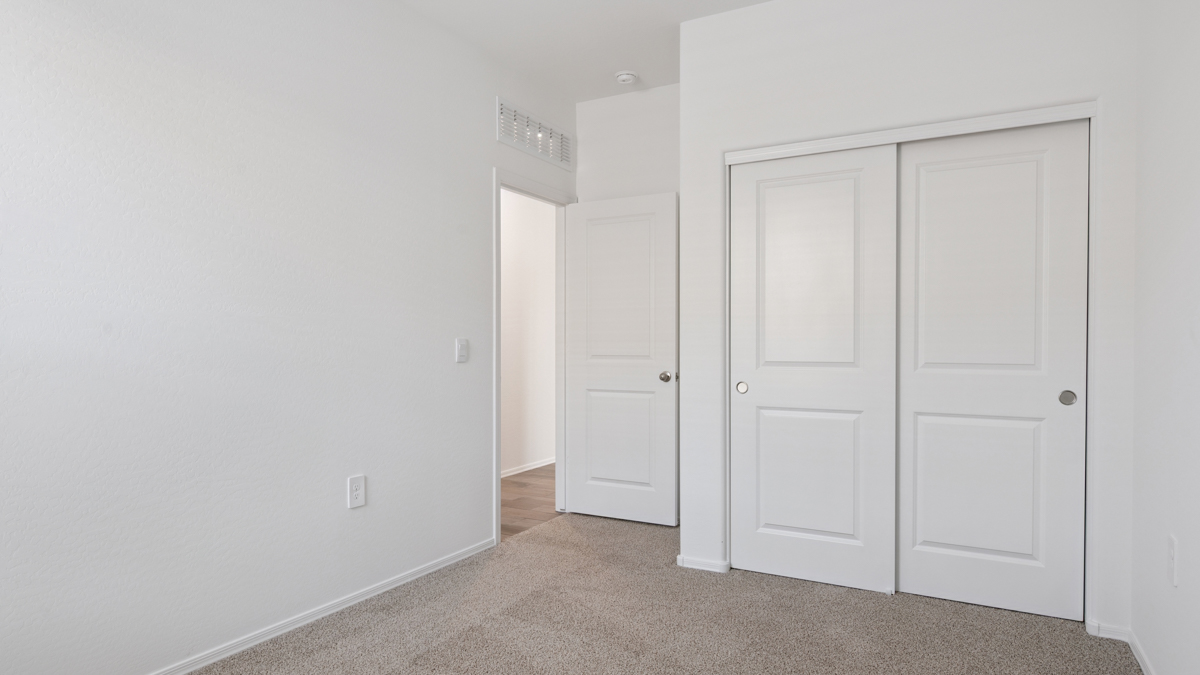 Comfortable guest bedroom featuring neutral-toned walls and a large closet.