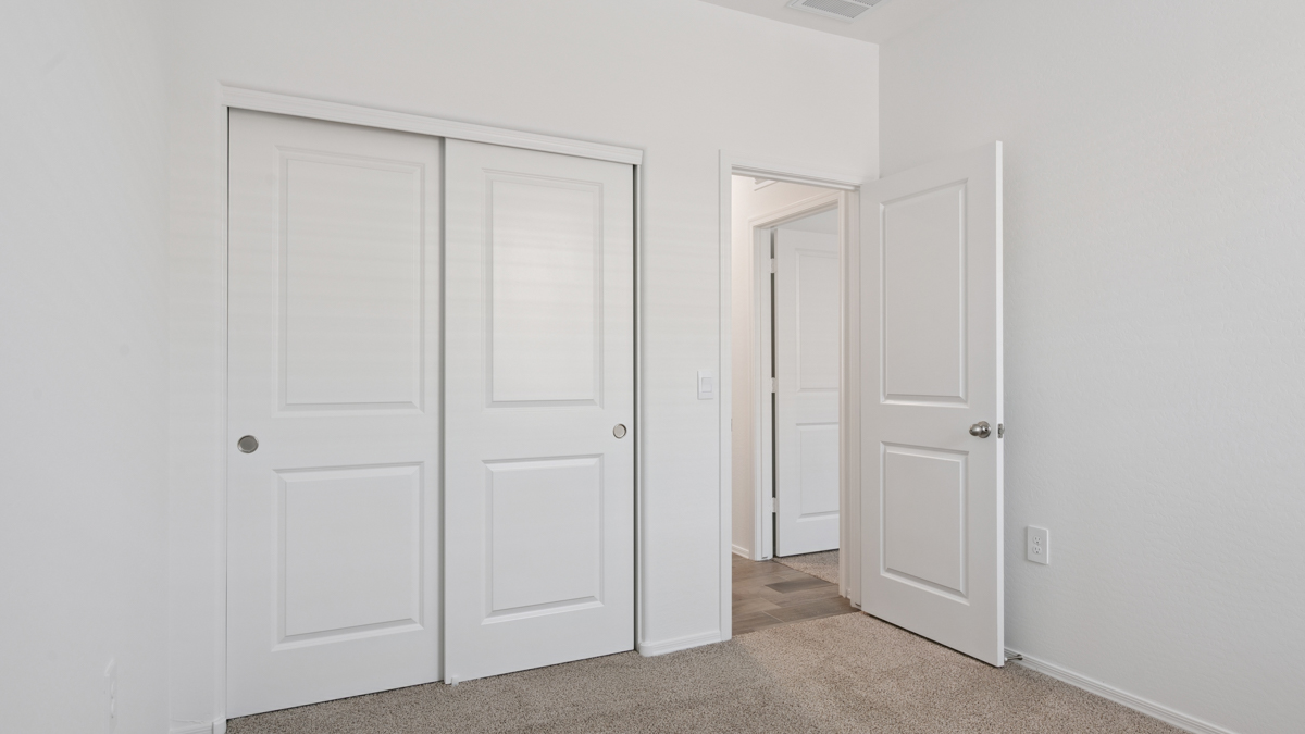 Comfortable guest bedroom featuring neutral-toned walls and a large closet.