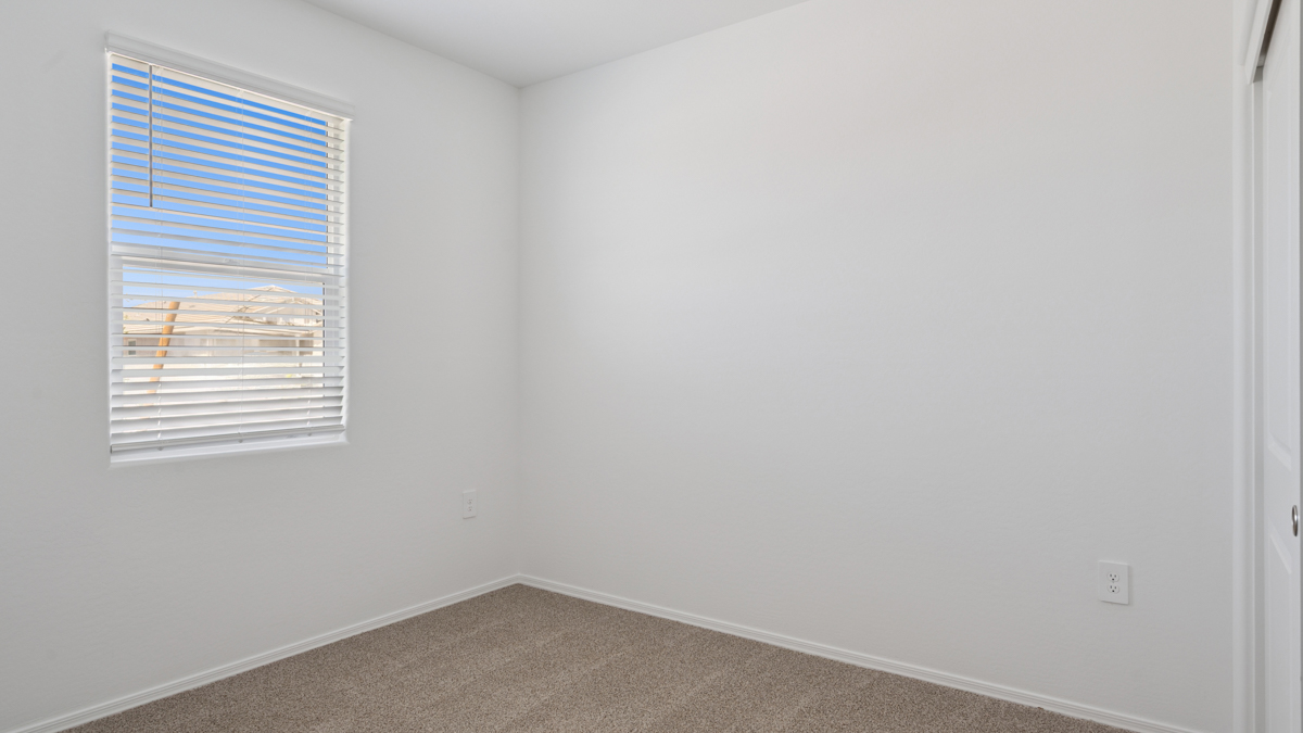 Comfortable guest bedroom featuring neutral-toned walls and a large closet.