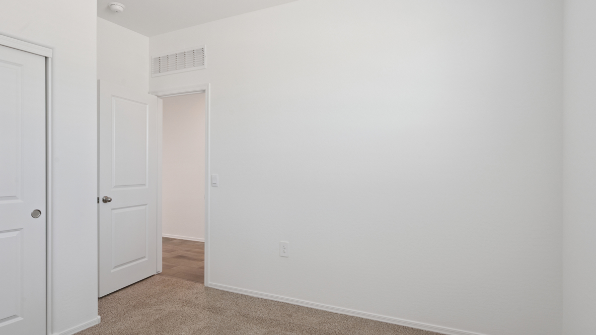 Comfortable guest bedroom featuring neutral-toned walls and a large closet.