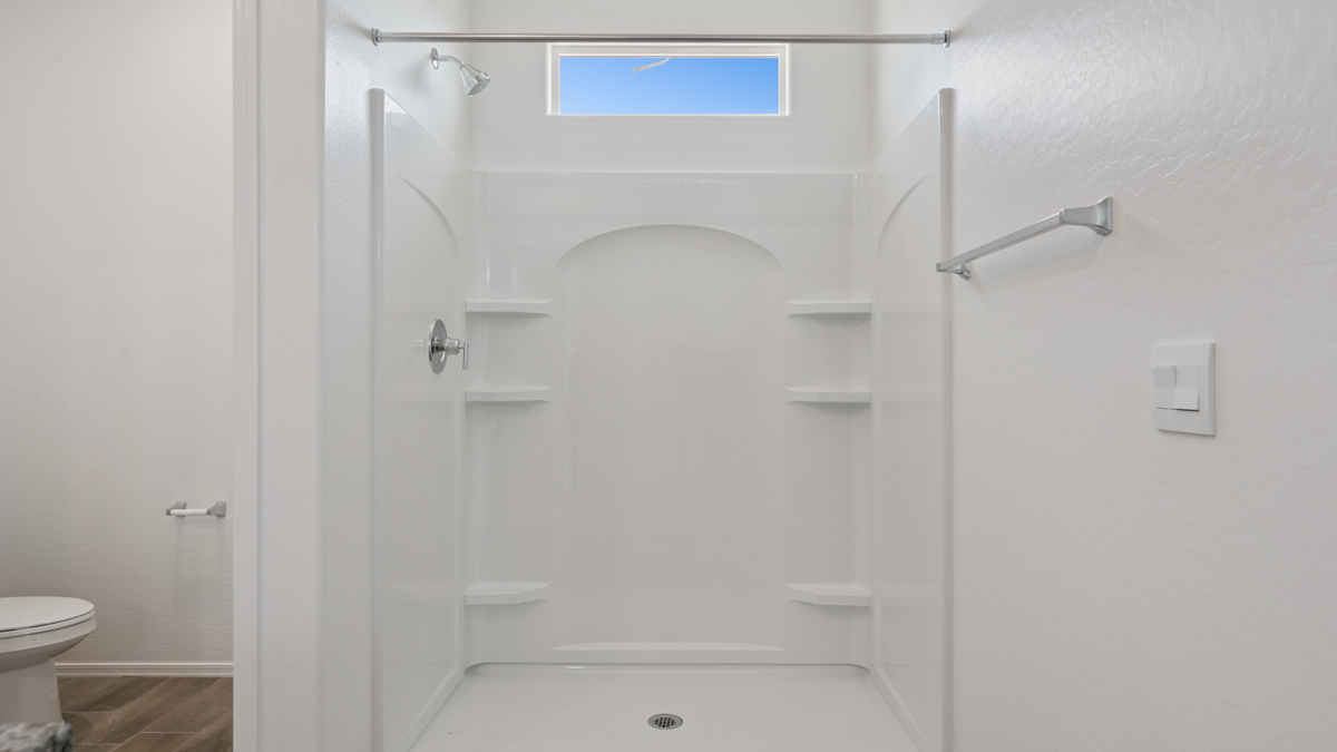 Modern primary bathroom with double vanity, granite countertops with a walk-in shower and a walk-in closet.