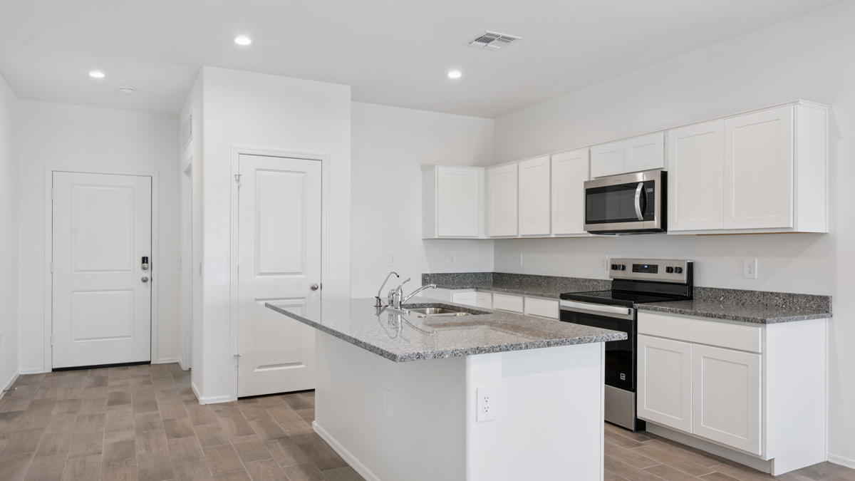 Bright and spacious kitchen with granite countertops, stainless steel appliances, and an island with bar seating.
