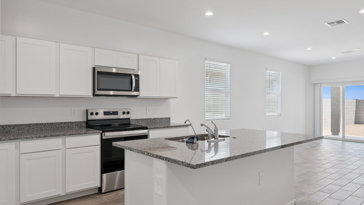 Bright and spacious kitchen with granite countertops, stainless steel appliances, and an island with bar seating.