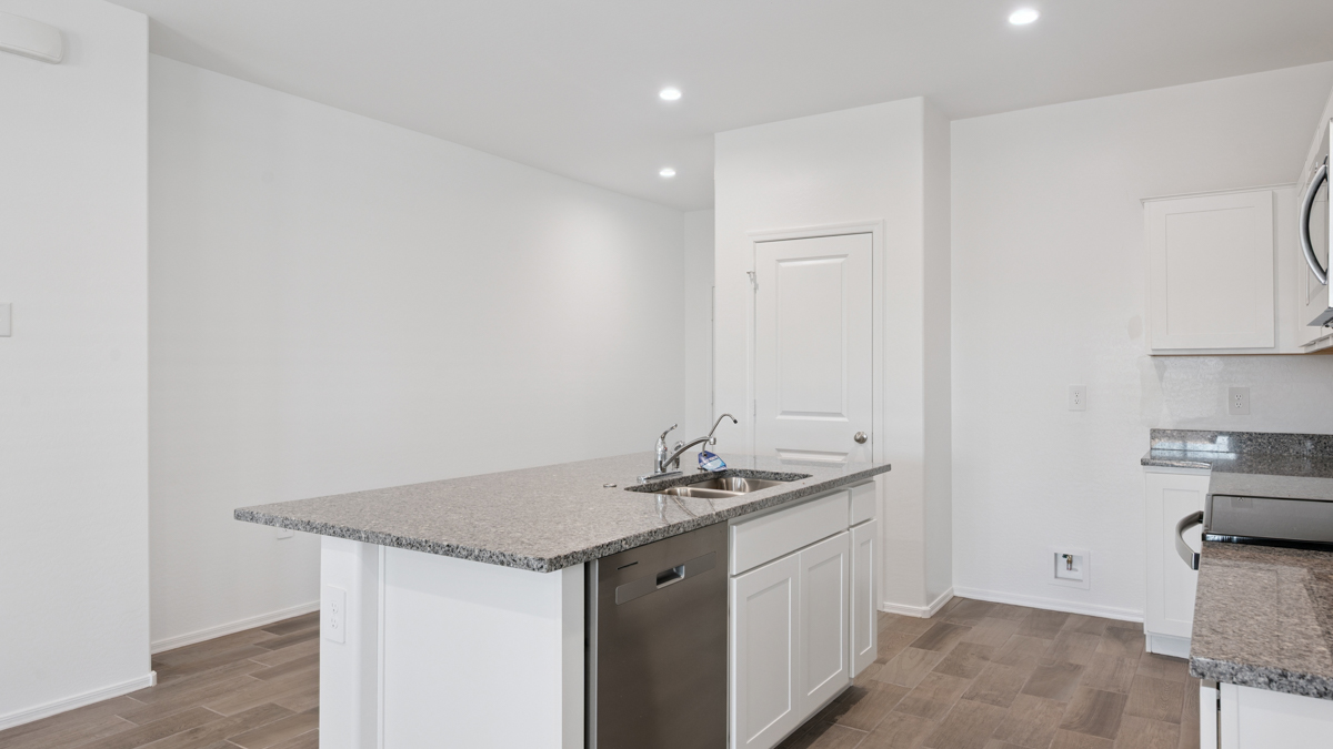 Bright and spacious kitchen with granite countertops, stainless steel appliances, and an island with bar seating.