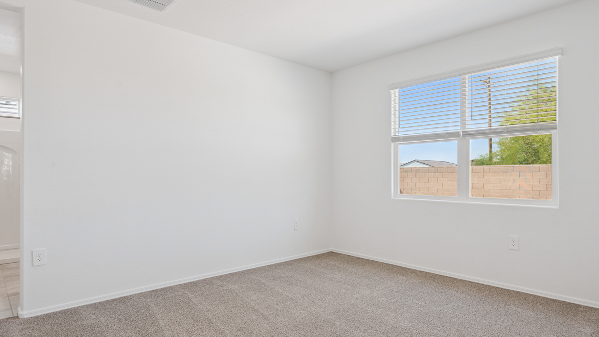 A spacious primary bedroom emphasizing open space and natural lighting.