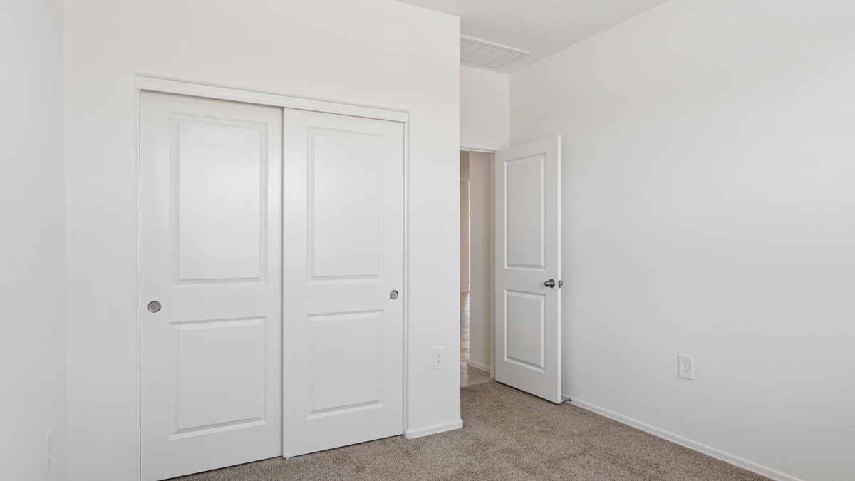 Comfortable guest bedroom featuring neutral-toned walls and a large closet.