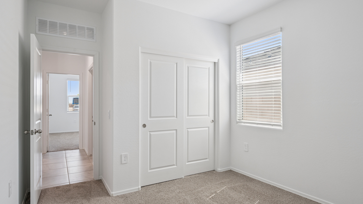 Comfortable guest bedroom featuring neutral-toned walls and a large closet.