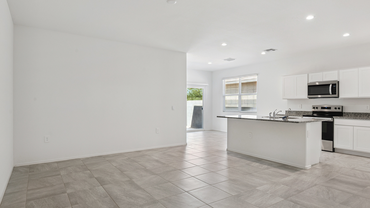 Bright and spacious kitchen with granite countertops, stainless steel appliances, and an island with bar seating.