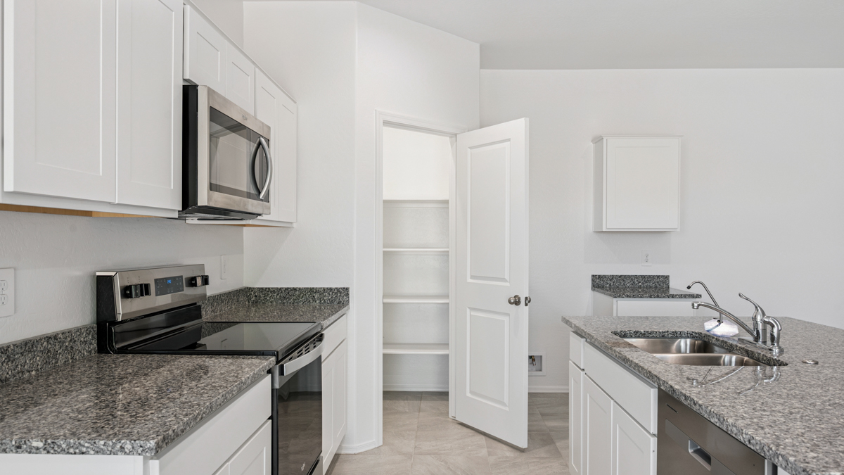 Bright and spacious kitchen with granite countertops, stainless steel appliances, and an island with bar seating.