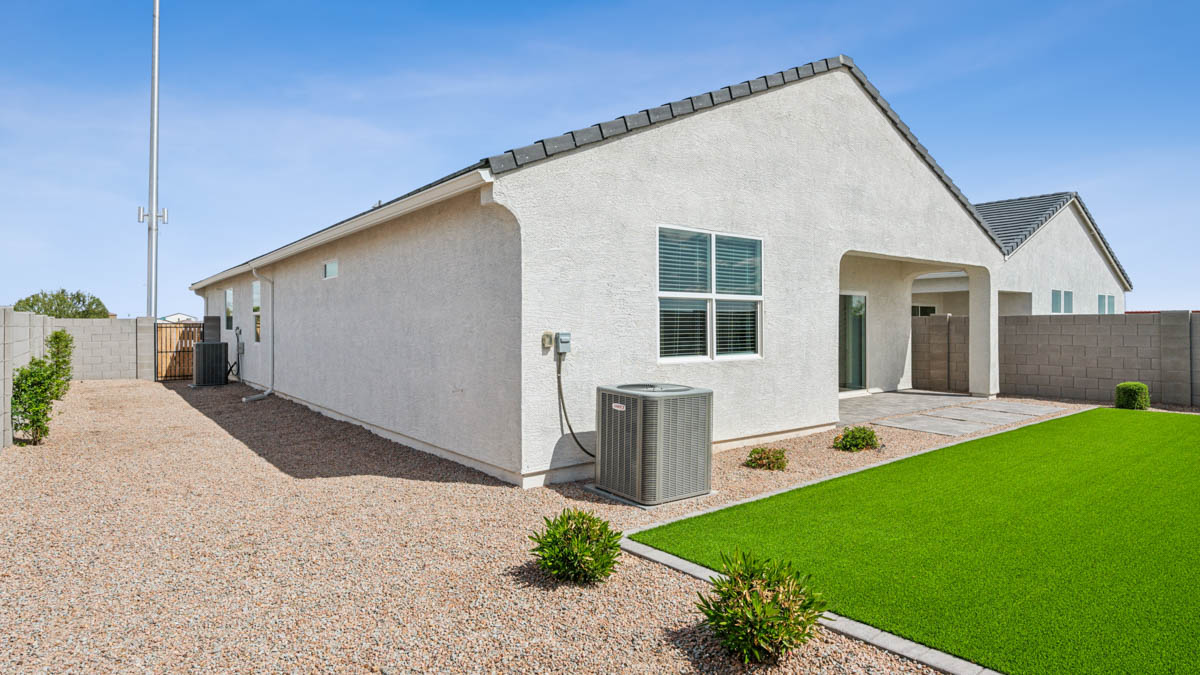 Outdoor covered patio with seating area overlooking a well-maintained lawn, perfect for relaxation.