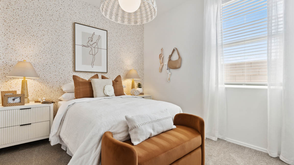 A vibrant kids' bedroom showcasing a neatly made bed, a stylish dresser, and a playful painting that adds charm.