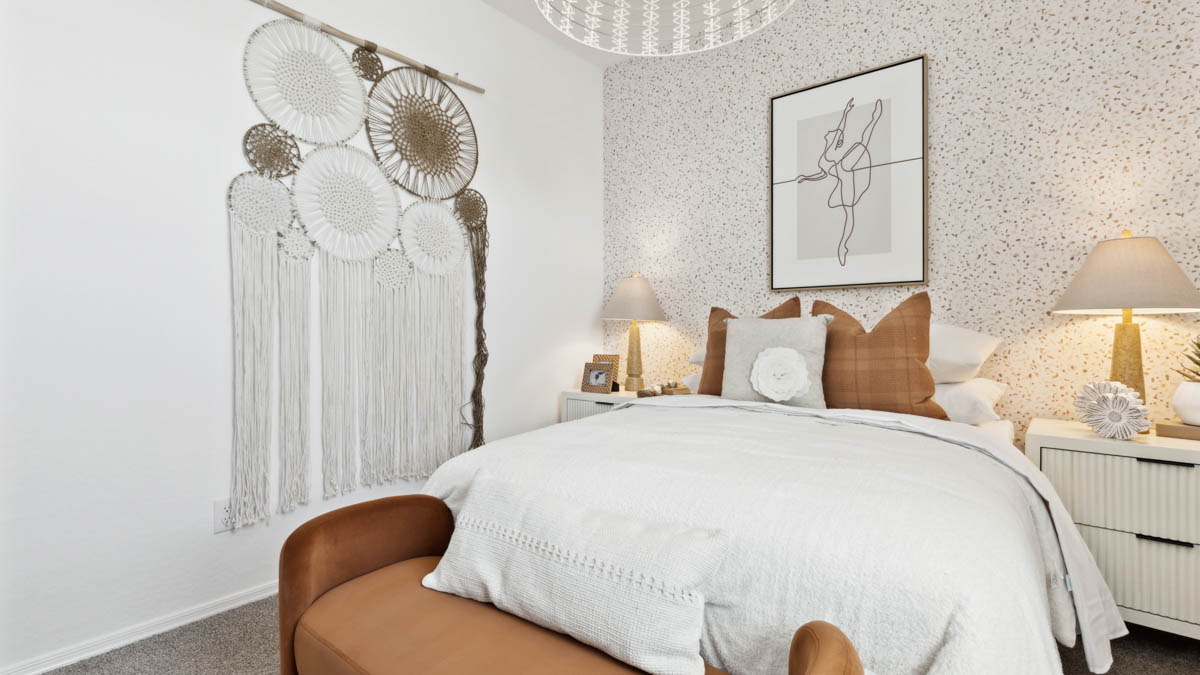 A vibrant kids' bedroom showcasing a neatly made bed, a stylish dresser, and a playful painting that adds charm.