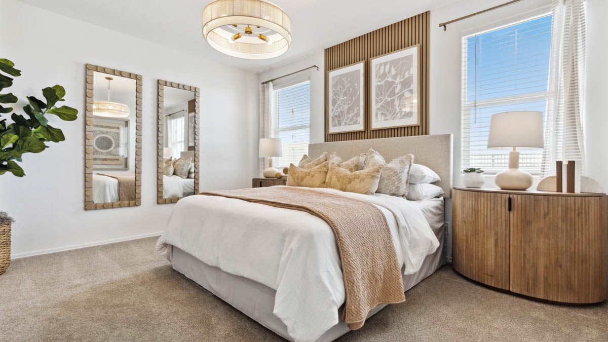 A spacious primary bedroom emphasizing open space and natural lighting.