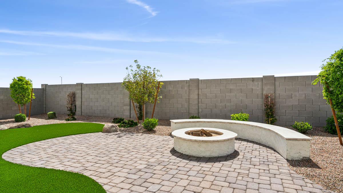 Outdoor covered patio with seating area overlooking a well-maintained lawn, perfect for relaxation.