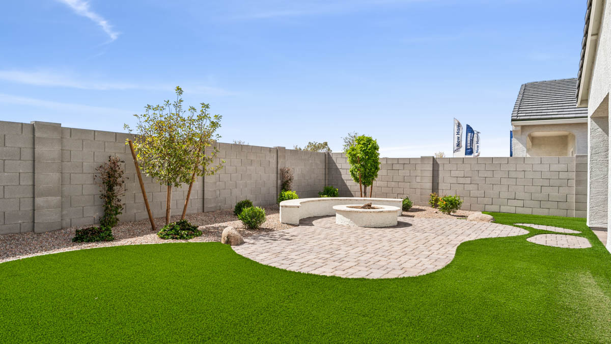 Outdoor covered patio with seating area overlooking a well-maintained lawn, perfect for relaxation.