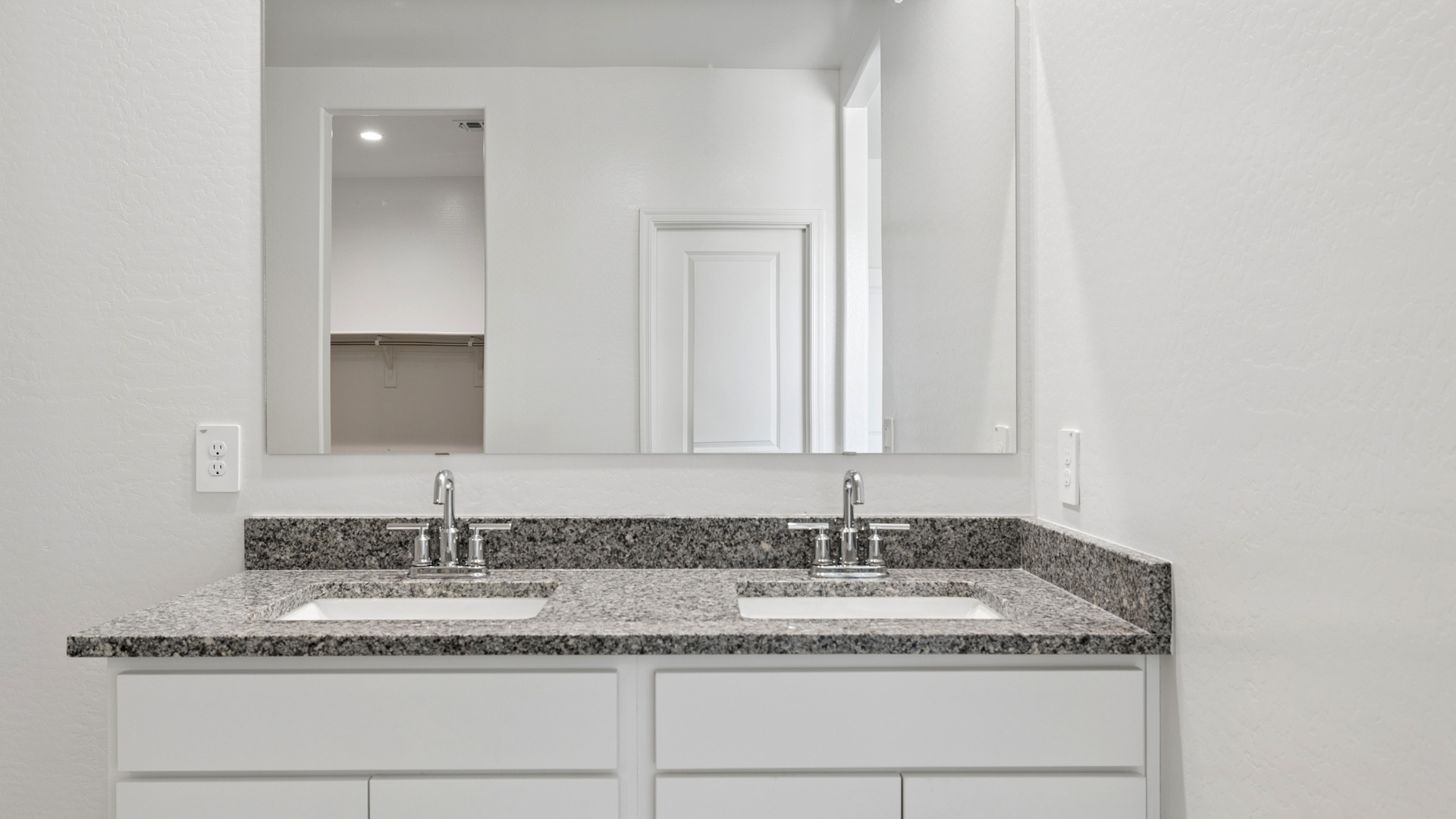 Primary bathroom with dual vanities.