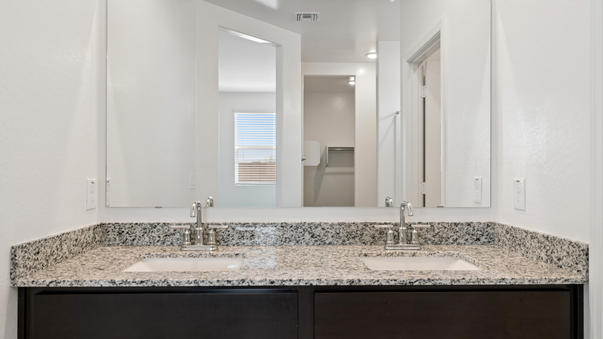 primary bathroom with dual vanities
