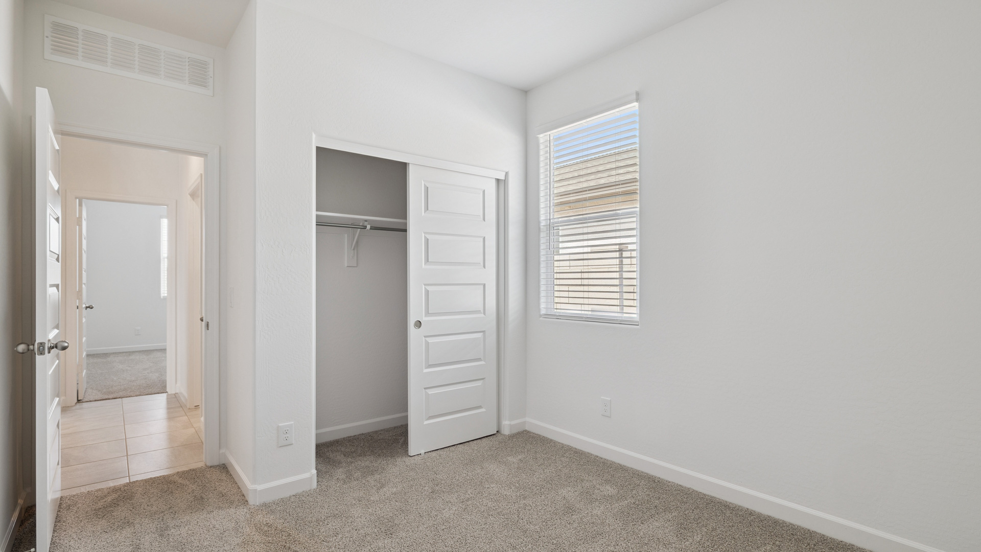 Comfortable guest bedroom featuring neutral-toned walls and a large closet.