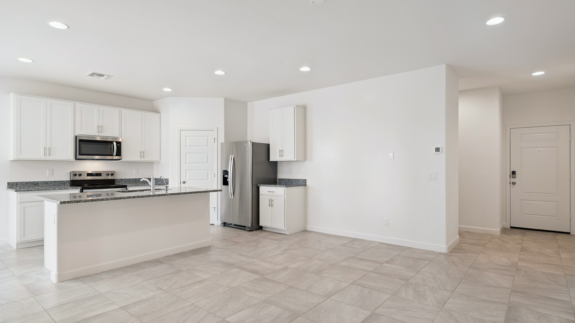 Bright and spacious kitchen with granite countertops, stainless steel appliances, and an island with bar seating.
