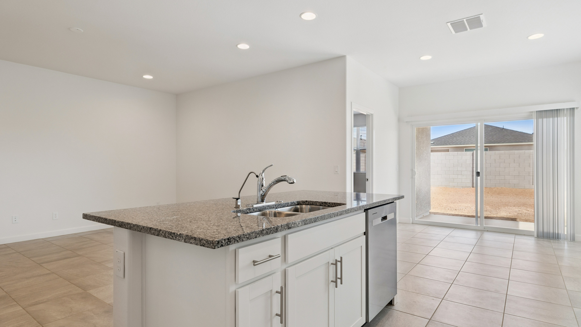 Bright and spacious kitchen with granite countertops, stainless steel appliances, and an island with bar seating.