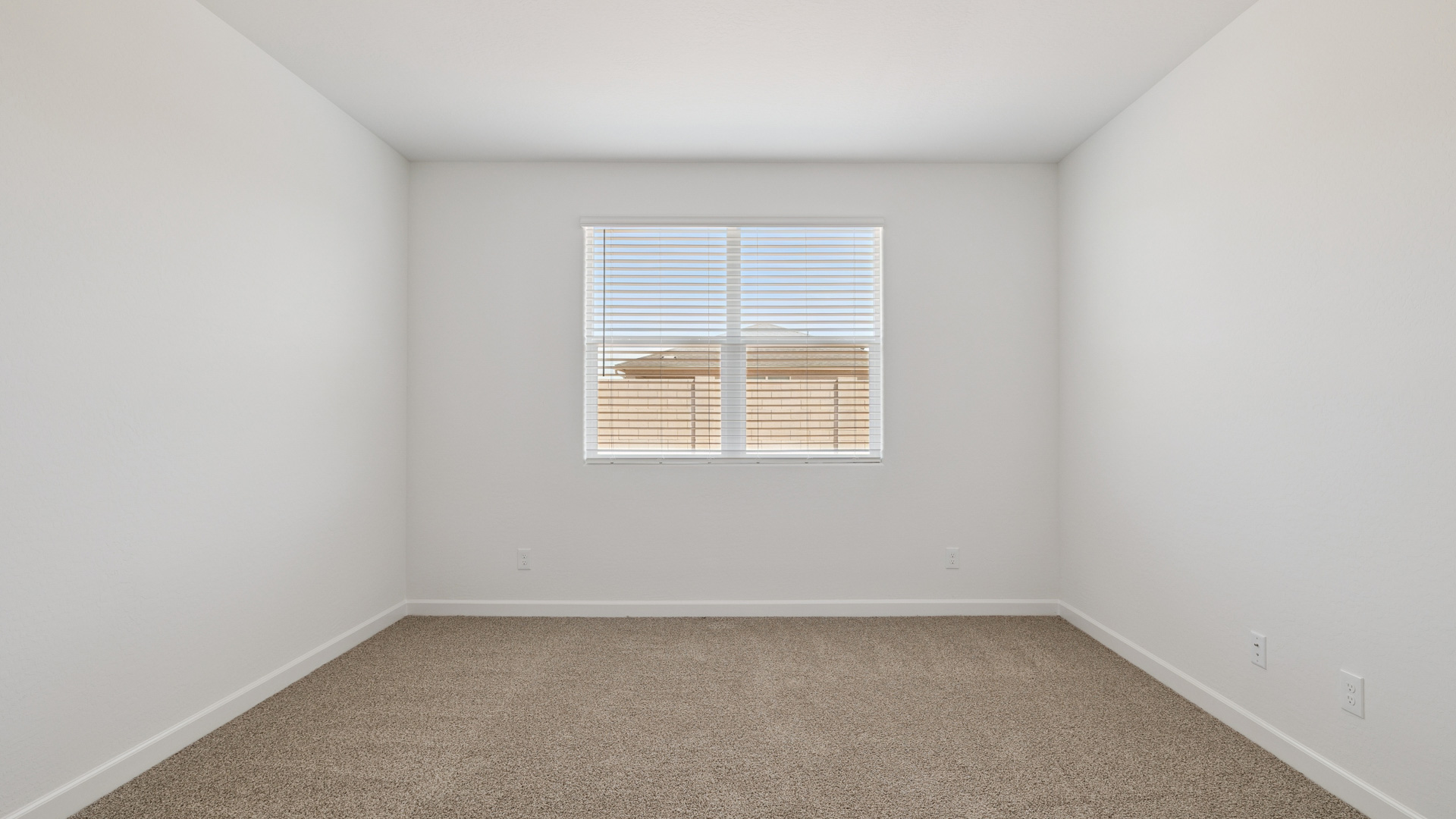 A spacious primary bedroom emphasizing open space and natural lighting.