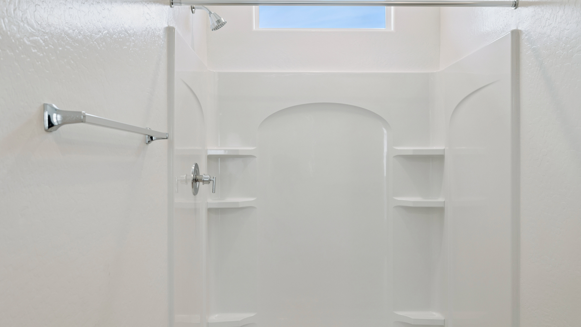 Modern primary bathroom with double vanity, granite countertops with a walk-in shower and a walk-in closet.