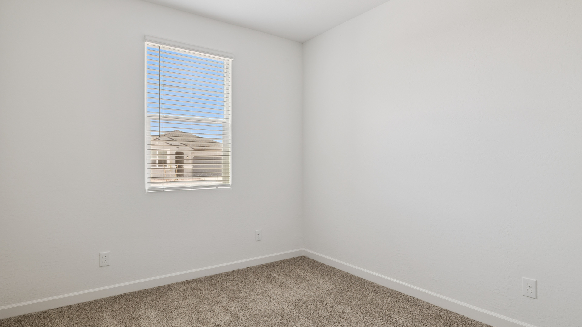 Comfortable guest bedroom featuring neutral-toned walls and a large closet.