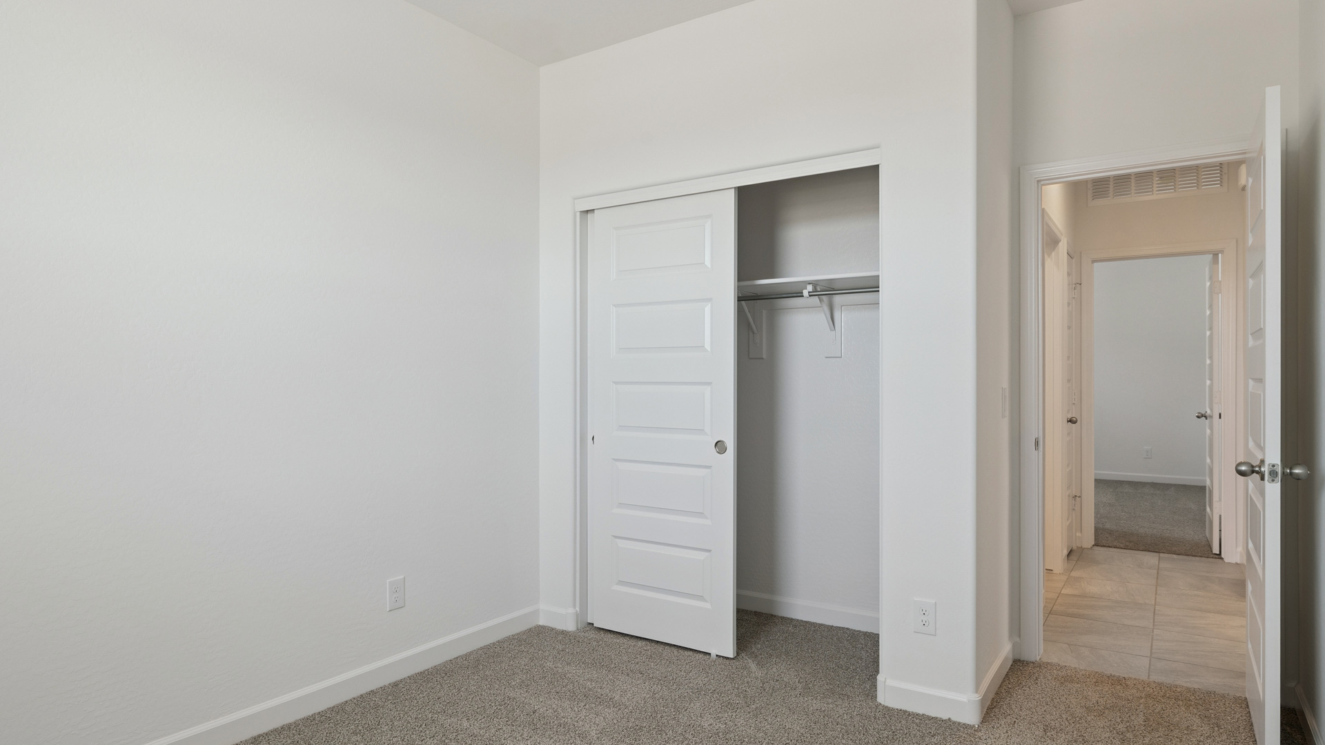 Comfortable guest bedroom featuring neutral-toned walls and a large closet.