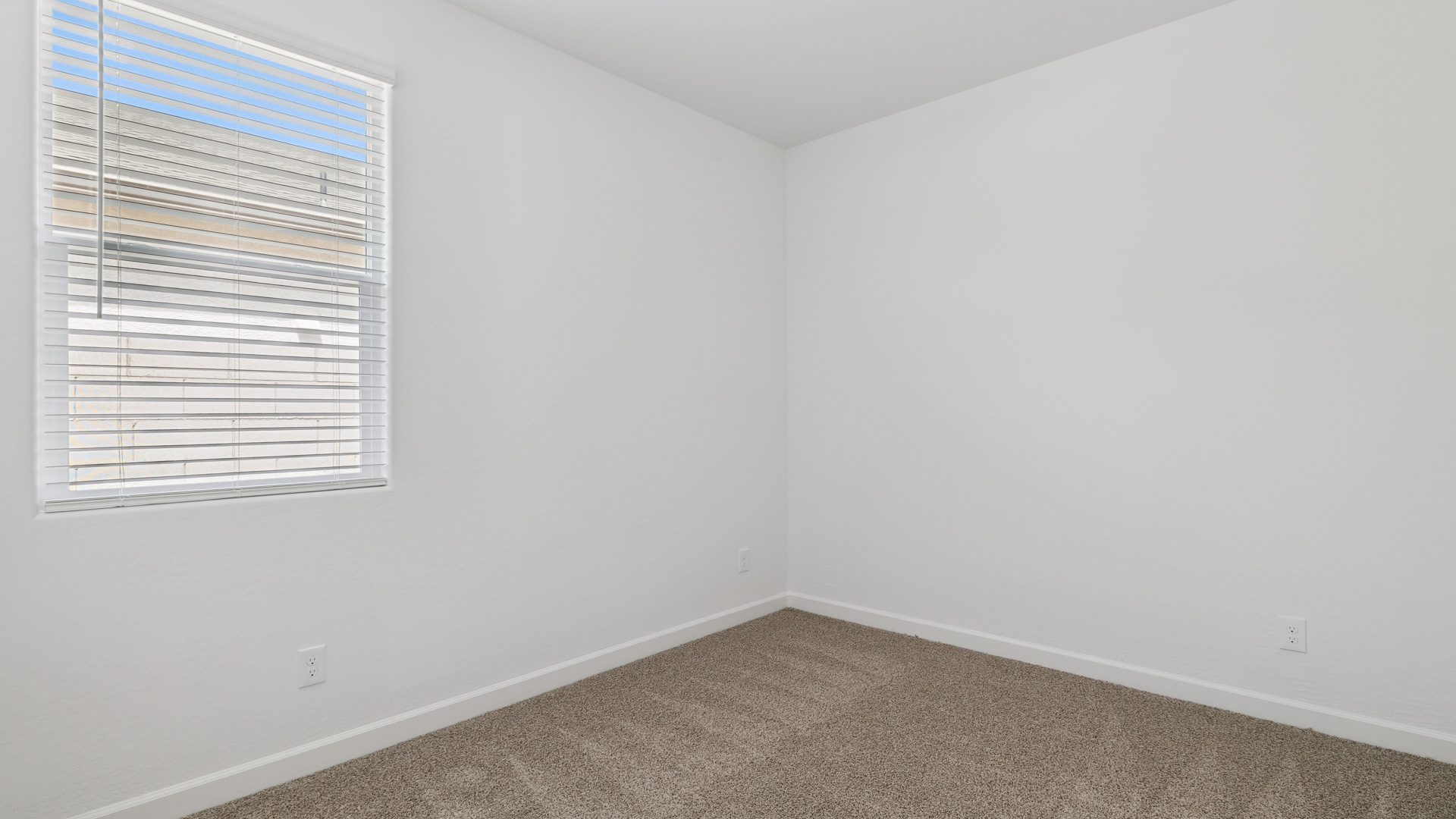 Comfortable guest bedroom featuring neutral-toned walls and a large closet.