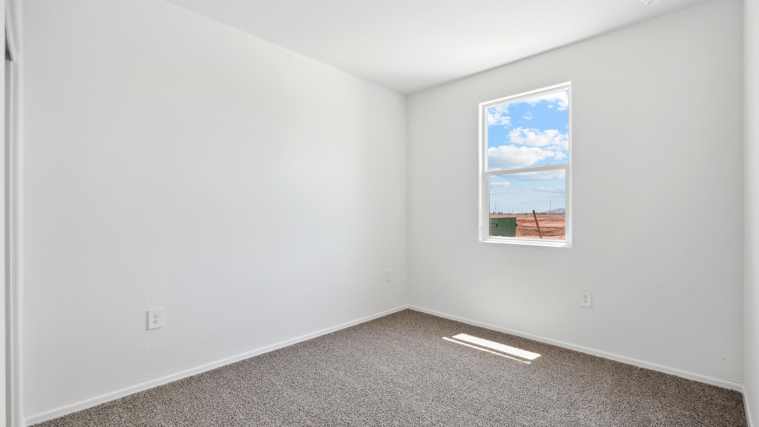 Comfortable guest bedroom featuring neutral-toned walls and a large closet.