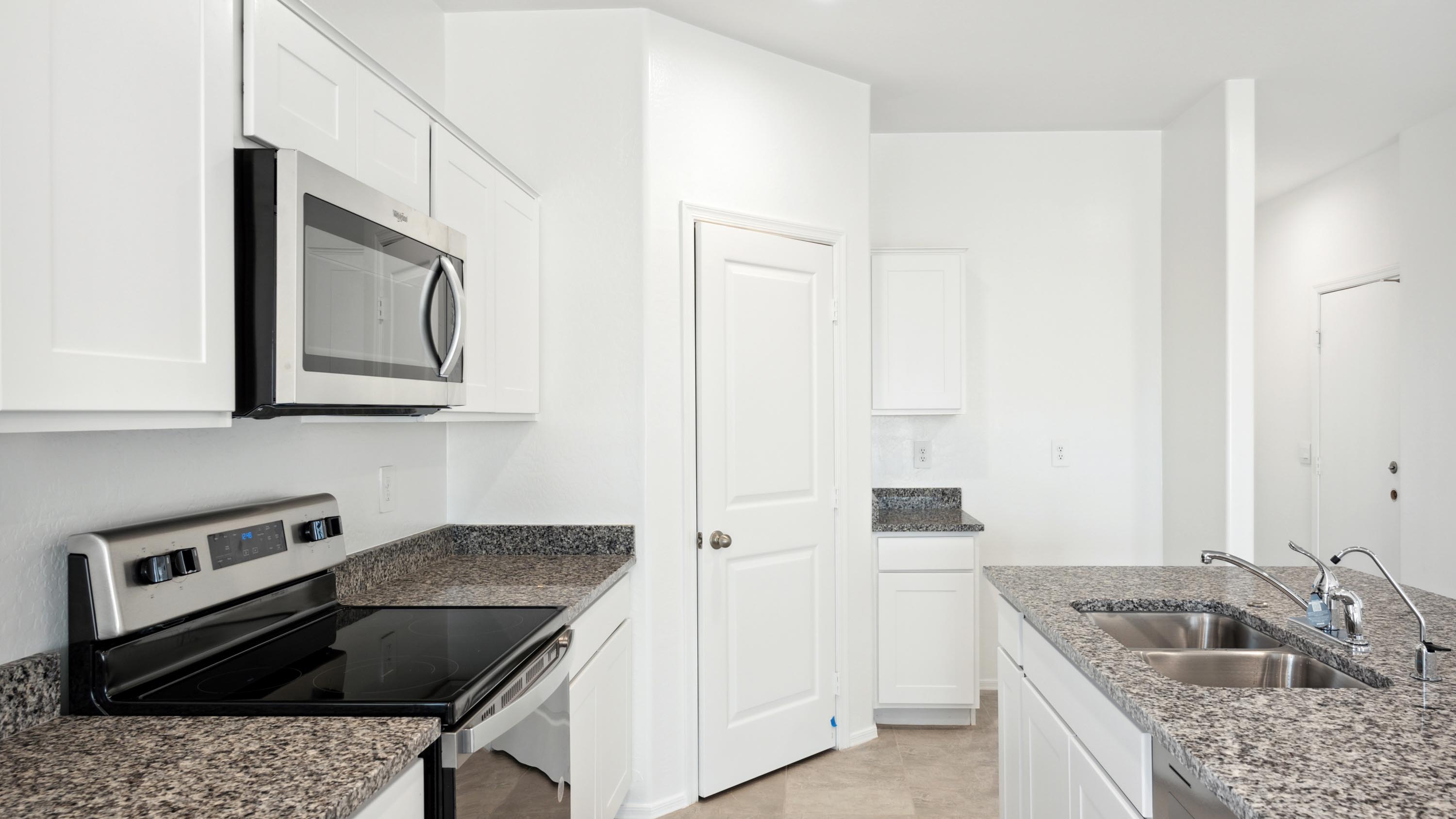 Bright and spacious kitchen with granite countertops, stainless steel appliances, and an island with bar seating.