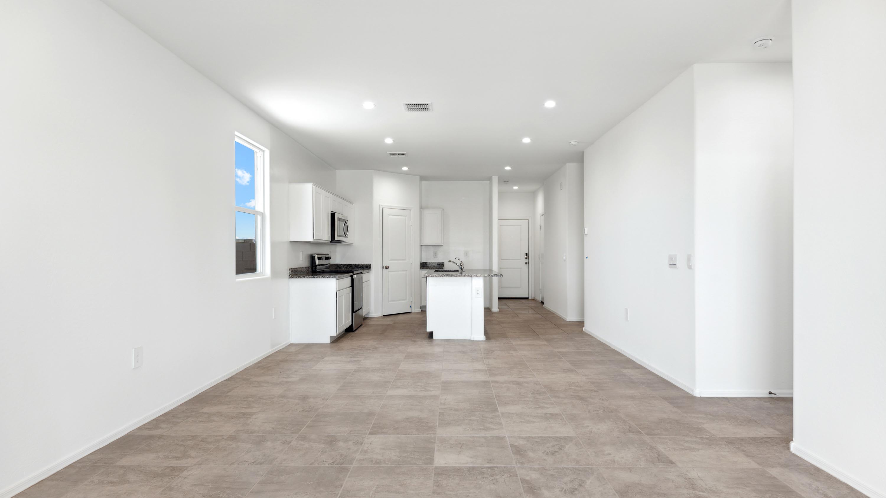 A well-organized living room that includes a kitchen and dining area, creating a warm and welcoming environment for gatherings.