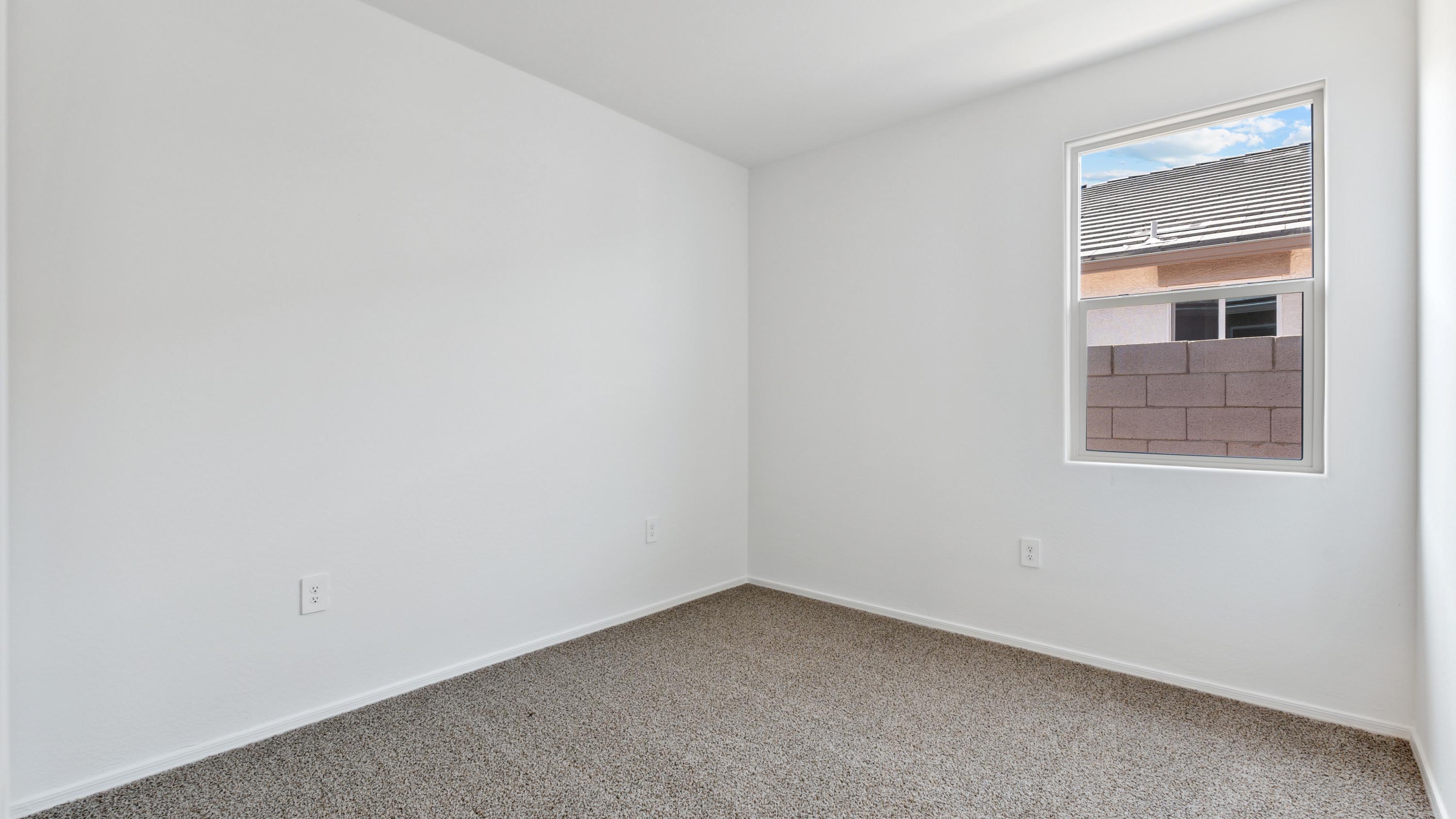 Comfortable guest bedroom featuring neutral-toned walls and a large closet.