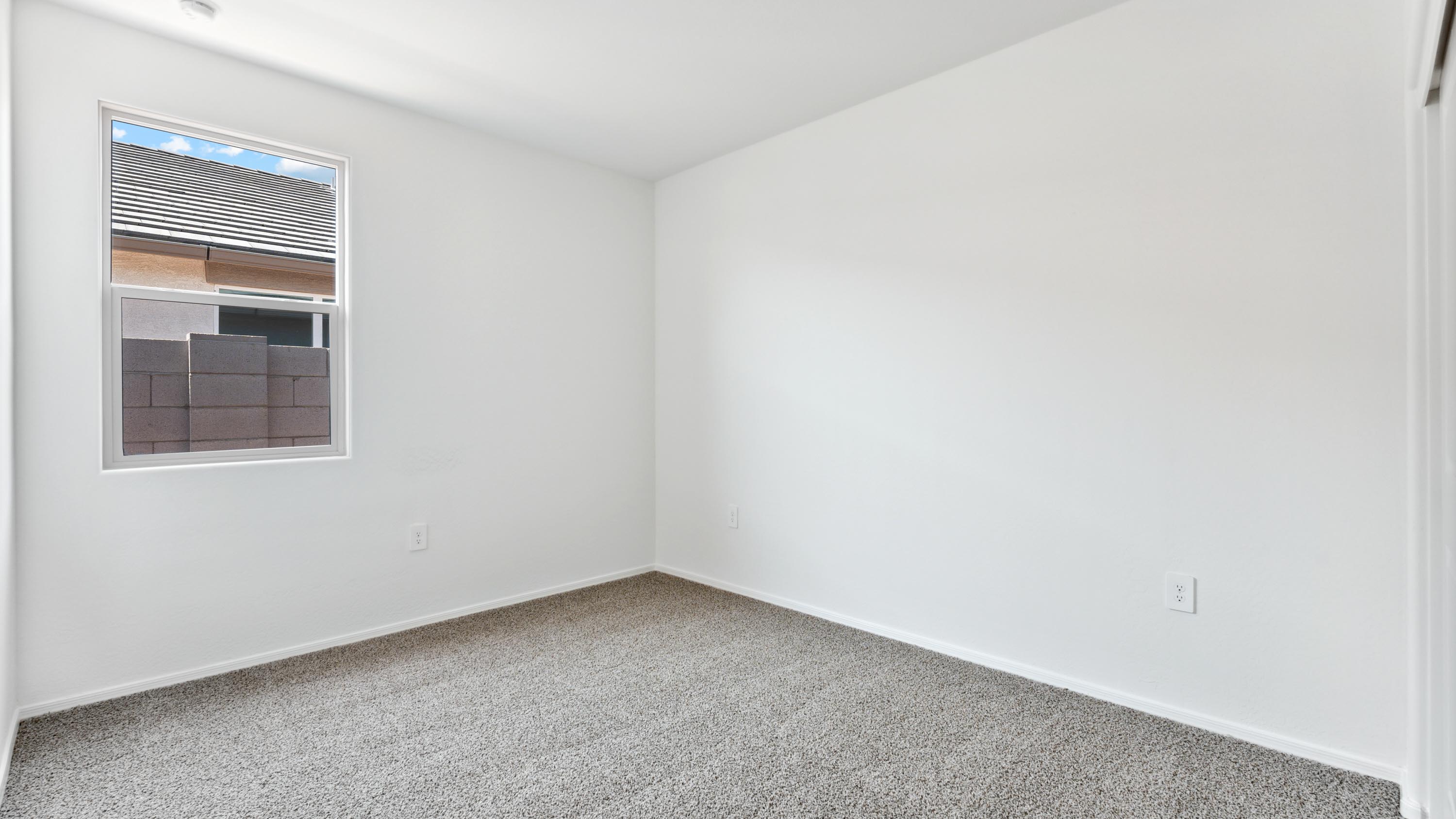 Comfortable guest bedroom featuring neutral-toned walls and a large closet.