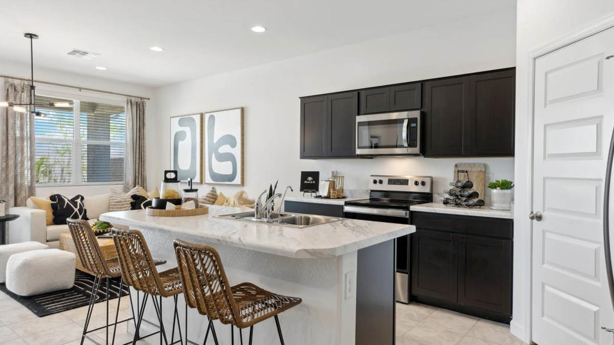Bright and spacious kitchen with porcelain countertops, stainless steel appliances, and an island with bar seating.