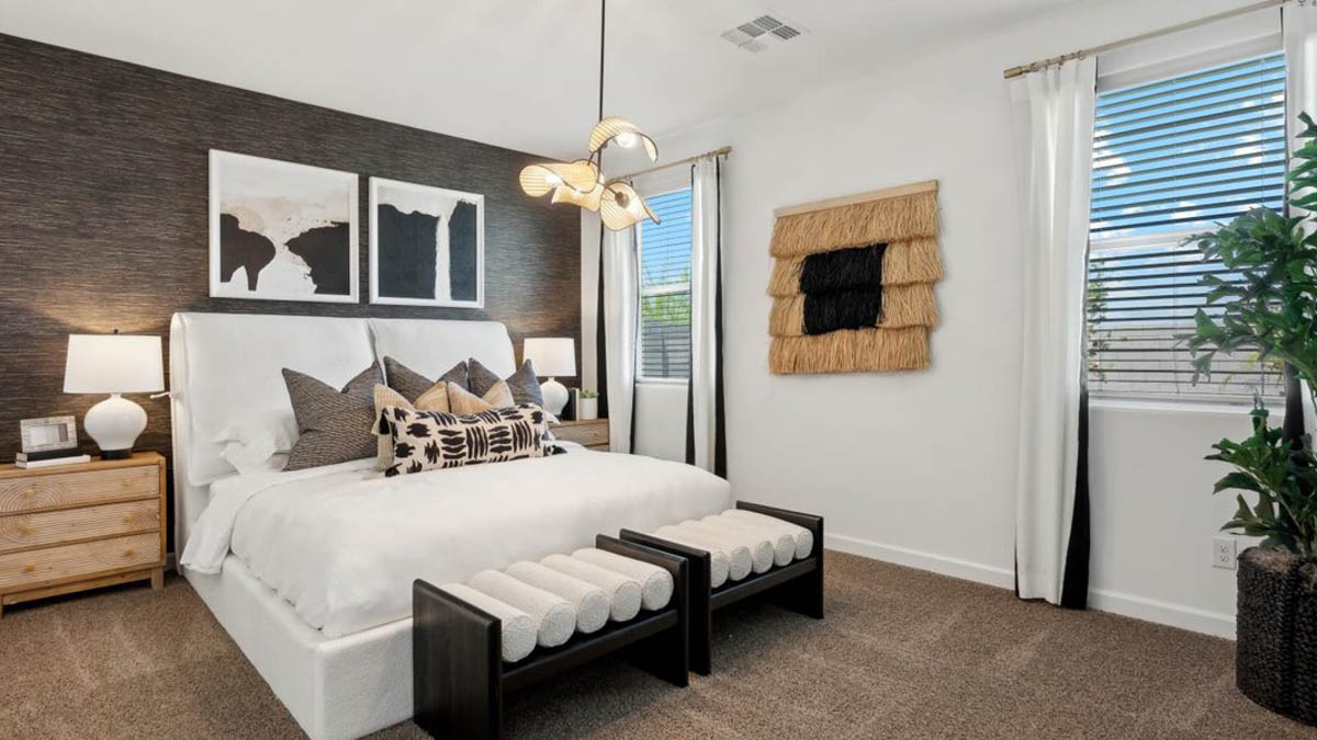 A spacious primary bedroom emphasizing open space and natural lighting.