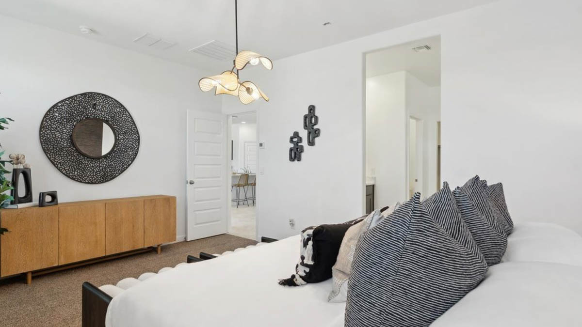 A spacious primary bedroom emphasizing open space and natural lighting.