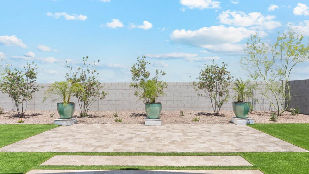 Outdoor covered patio with seating area overlooking a well-maintained lawn, perfect for relaxation.