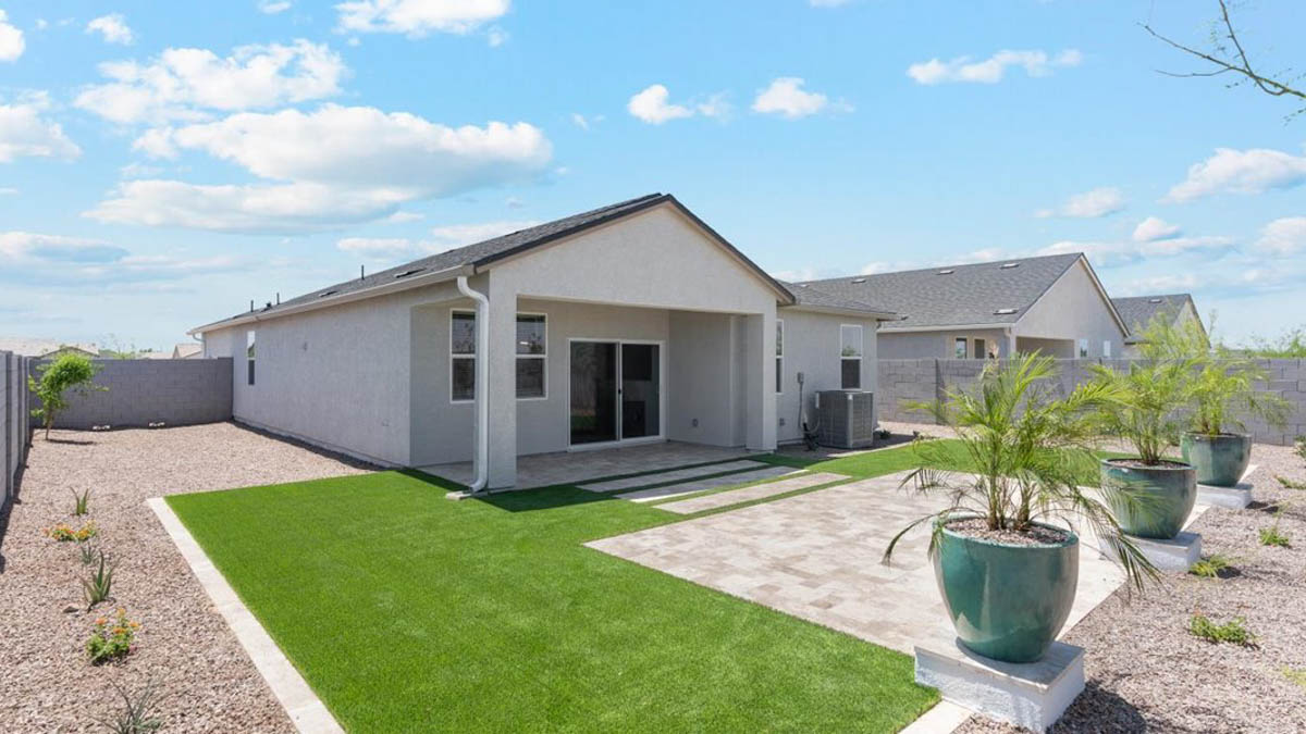 Outdoor covered patio with seating area overlooking a well-maintained lawn, perfect for relaxation.