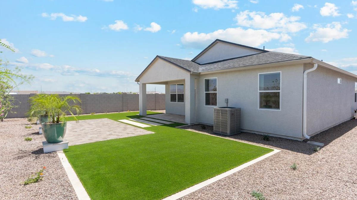 Outdoor covered patio with seating area overlooking a well-maintained lawn, perfect for relaxation.