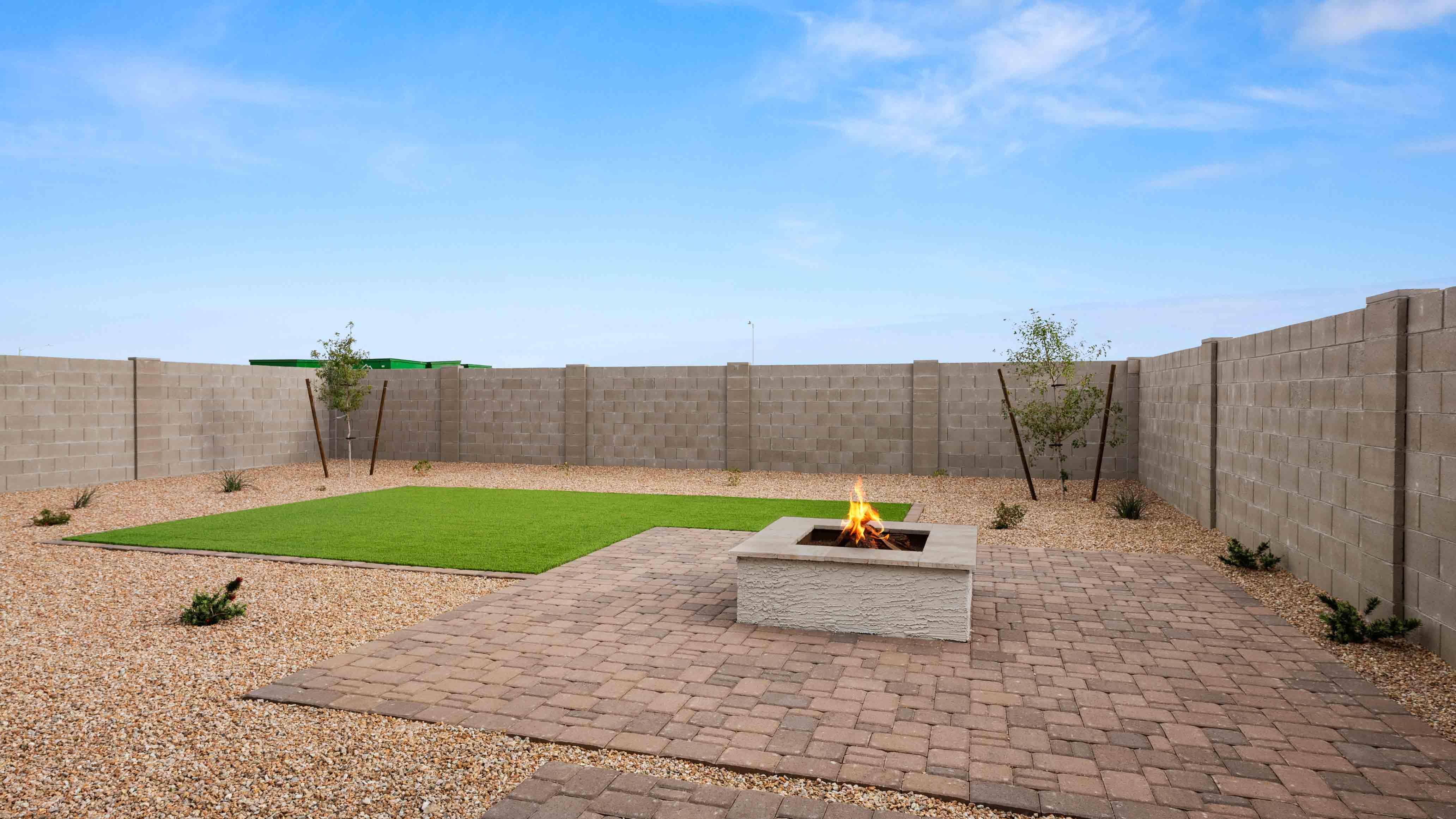Outdoor covered patio with seating area overlooking a well-maintained lawn, perfect for relaxation.