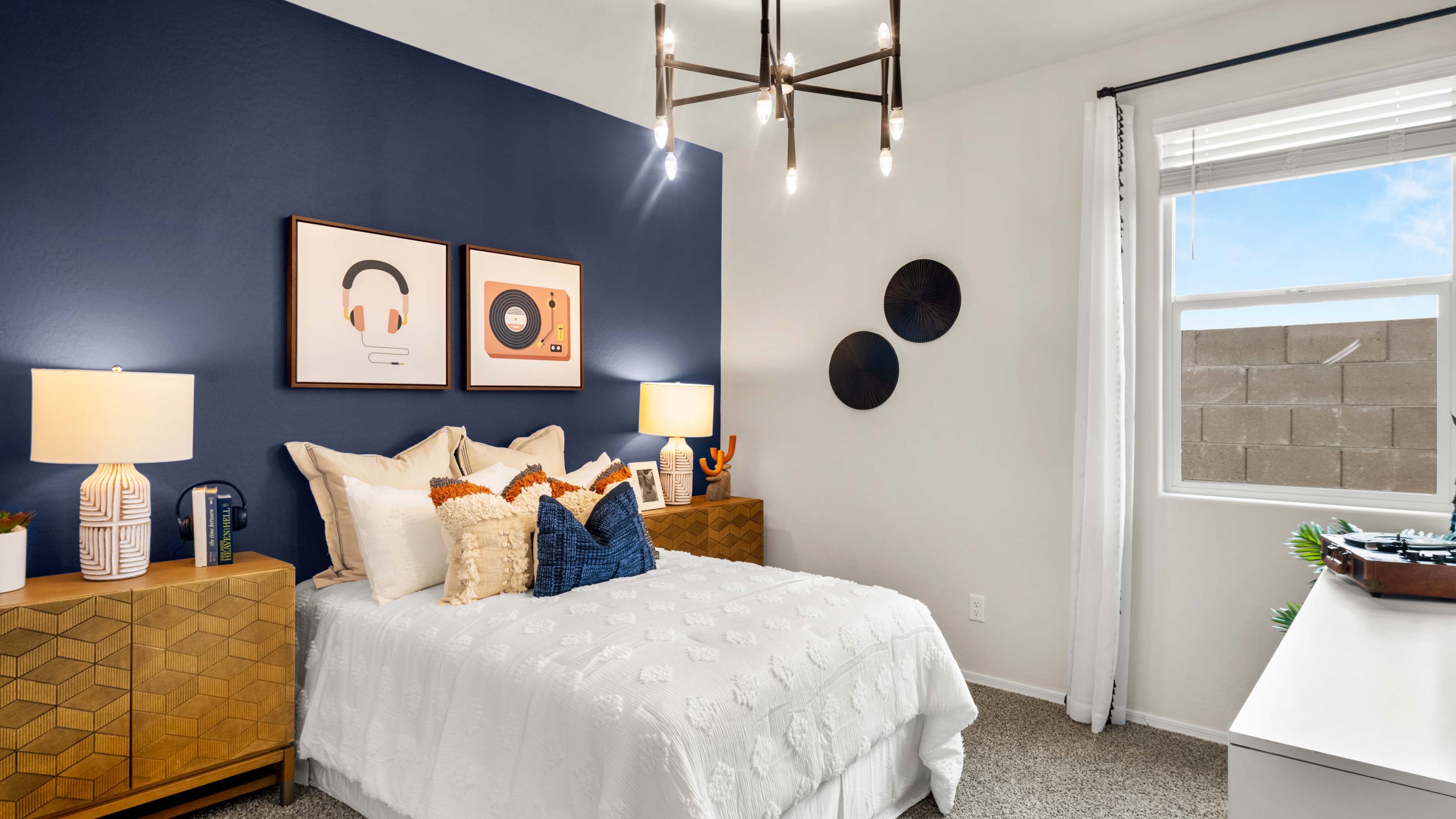 A vibrant kids' bedroom showcasing a neatly made bed, a stylish dresser, and a playful painting that adds charm.