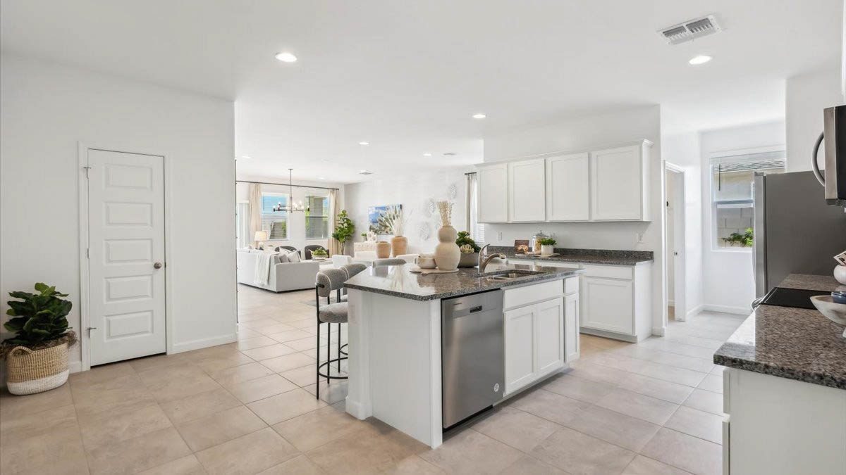 Bright and spacious kitchen with granite countertops, stainless steel appliances, and an island with bar seating.