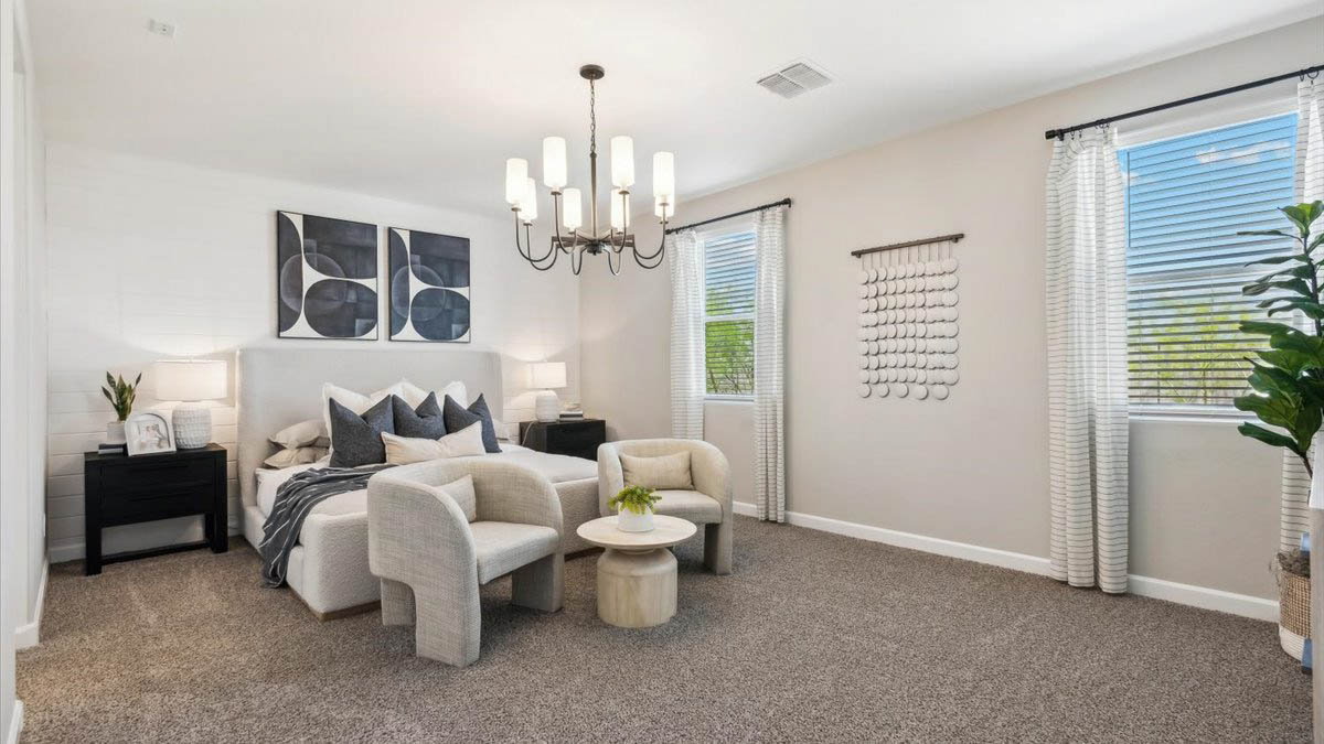 A spacious primary bedroom emphasizing open space and natural lighting.