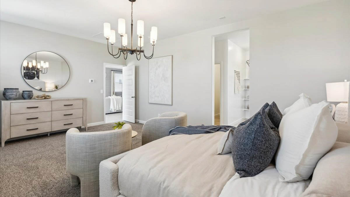 A spacious primary bedroom emphasizing open space and natural lighting.